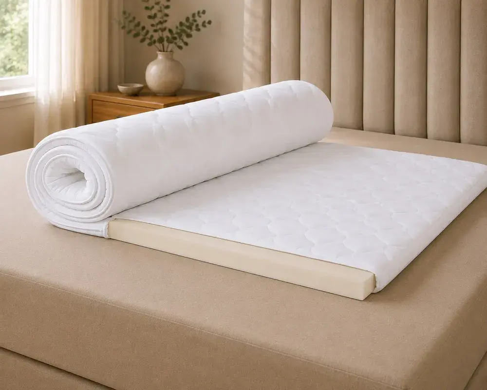 Hvid visco-topmadras, der er delvist rullet sammen, så skumlaget ses